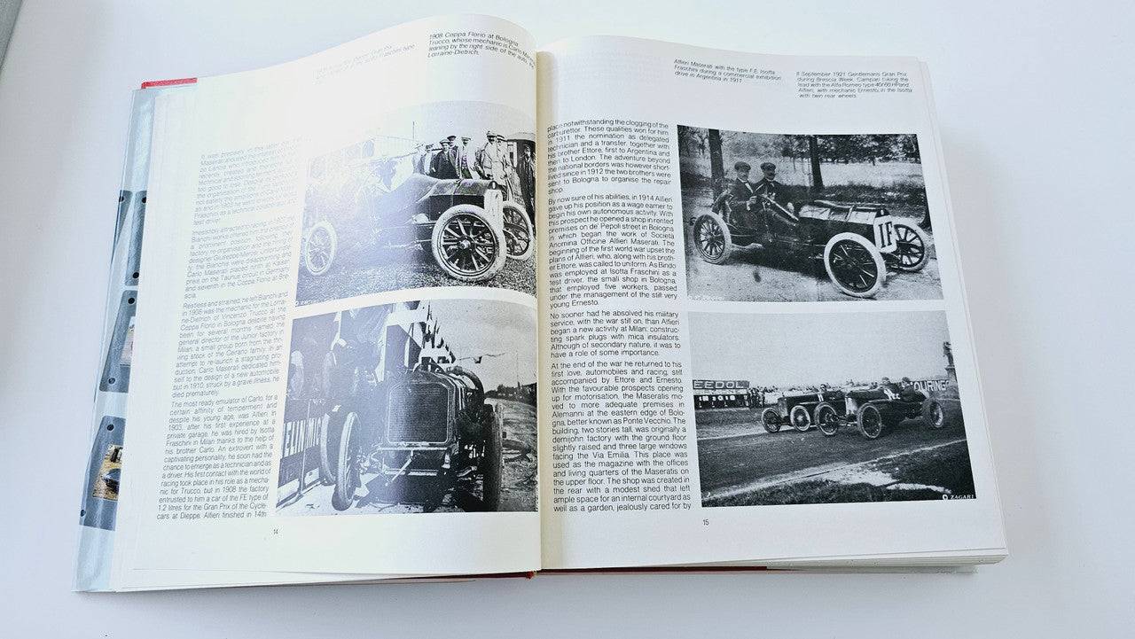 Classic car history book open to black-and-white vehicle photo spreads