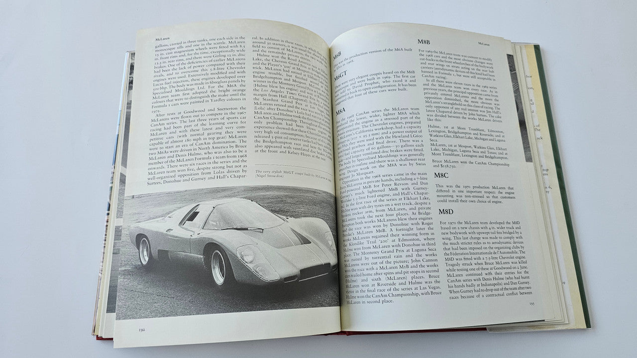 Sports racing book open with black-and-white race car photo and two columns of text