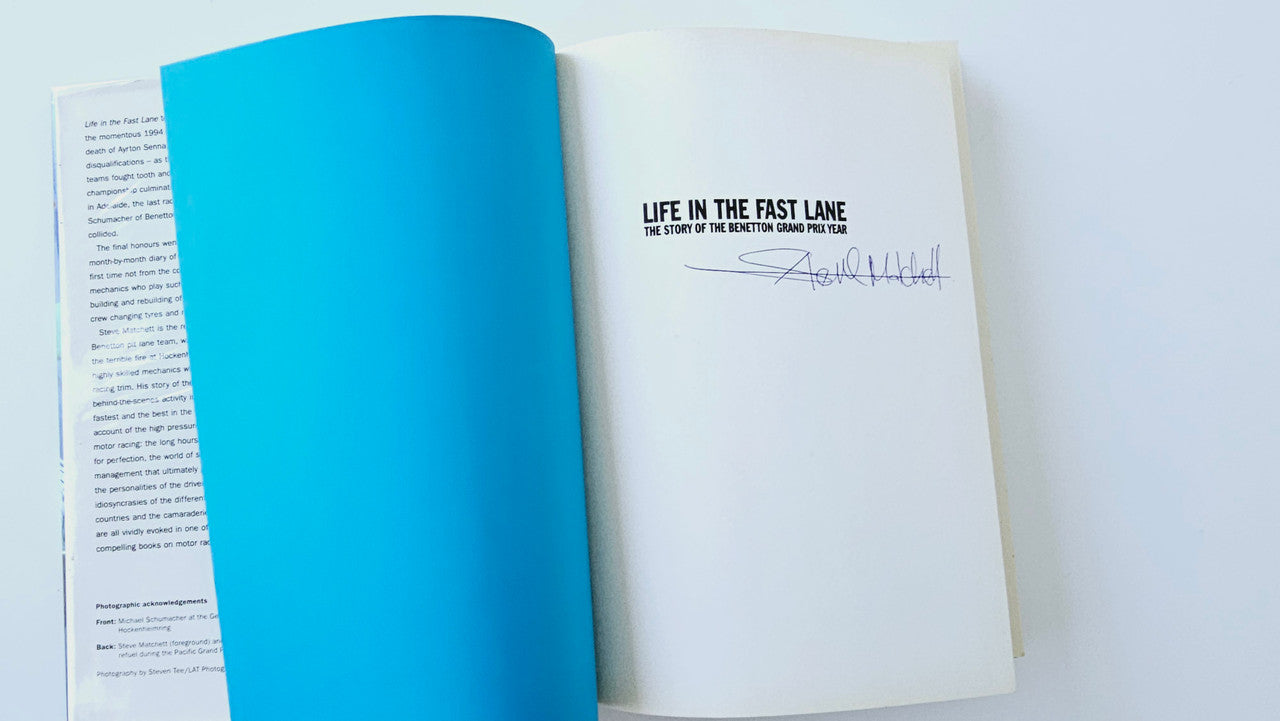 Open book with blue endpapers and signed title page on white sheet