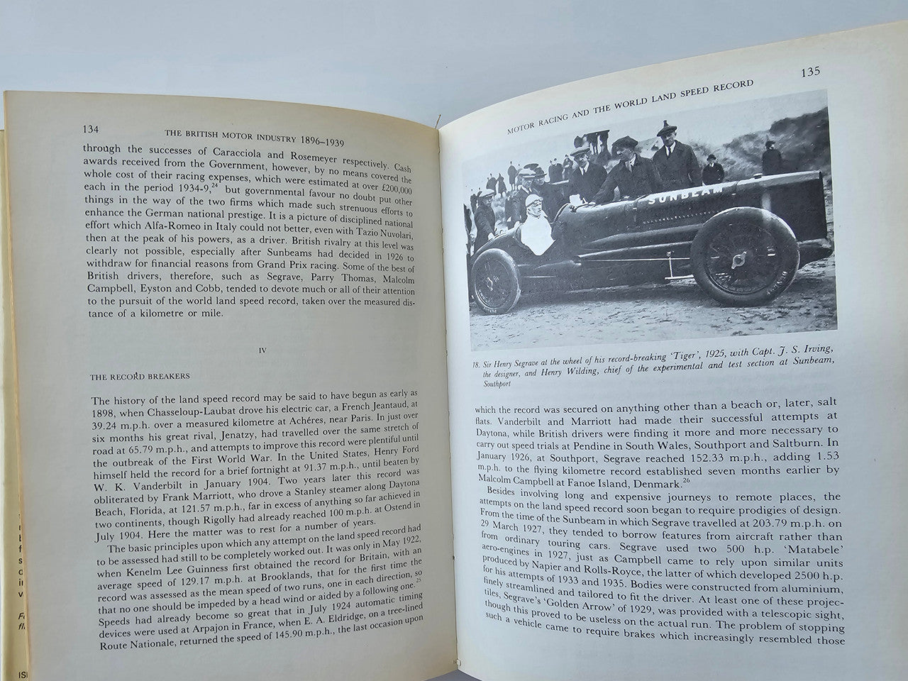 Open book on British motor industry history, with vintage car photos and text pages