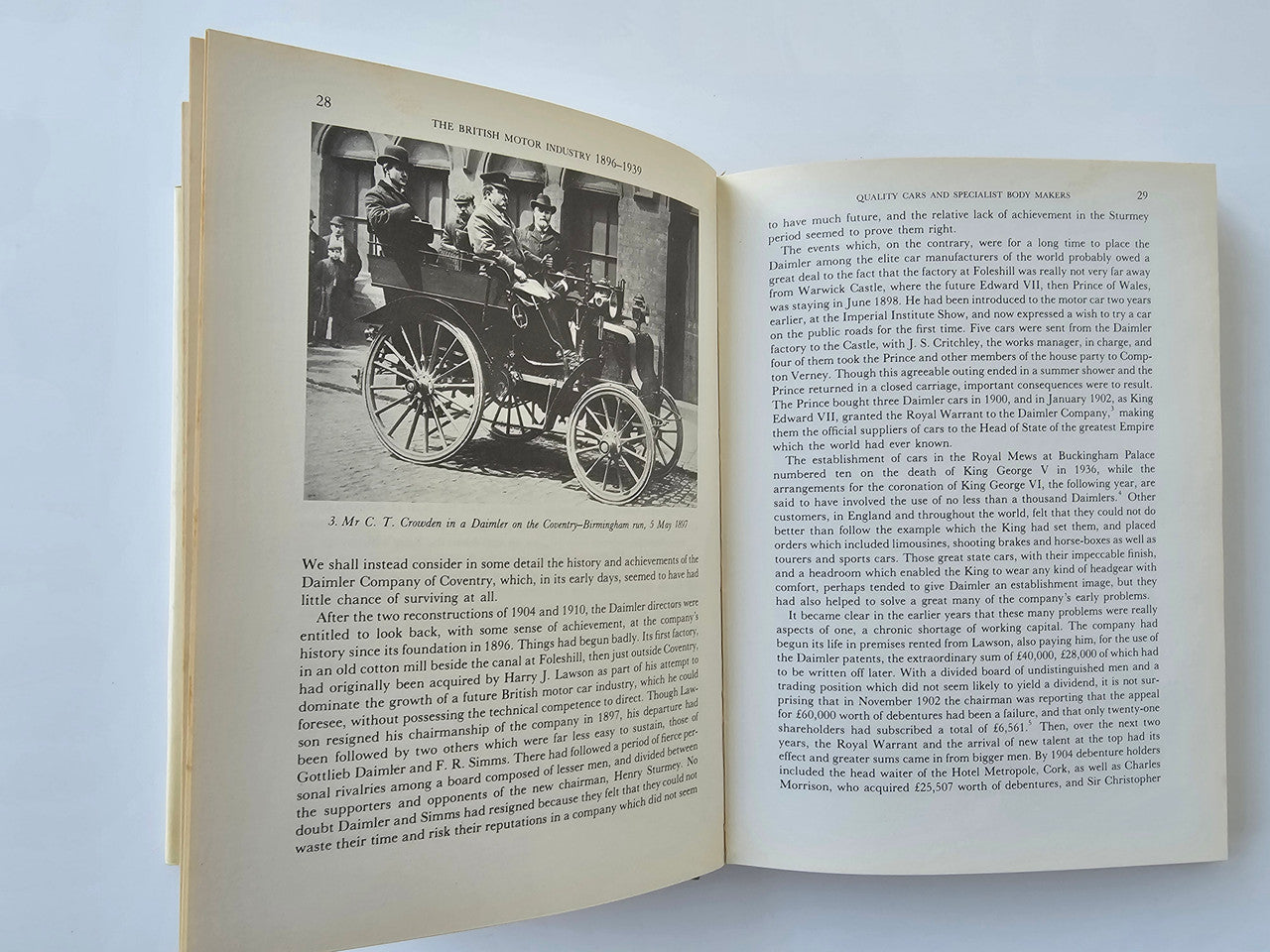 Open book with old motor carriage photo on left and paragraphs on right