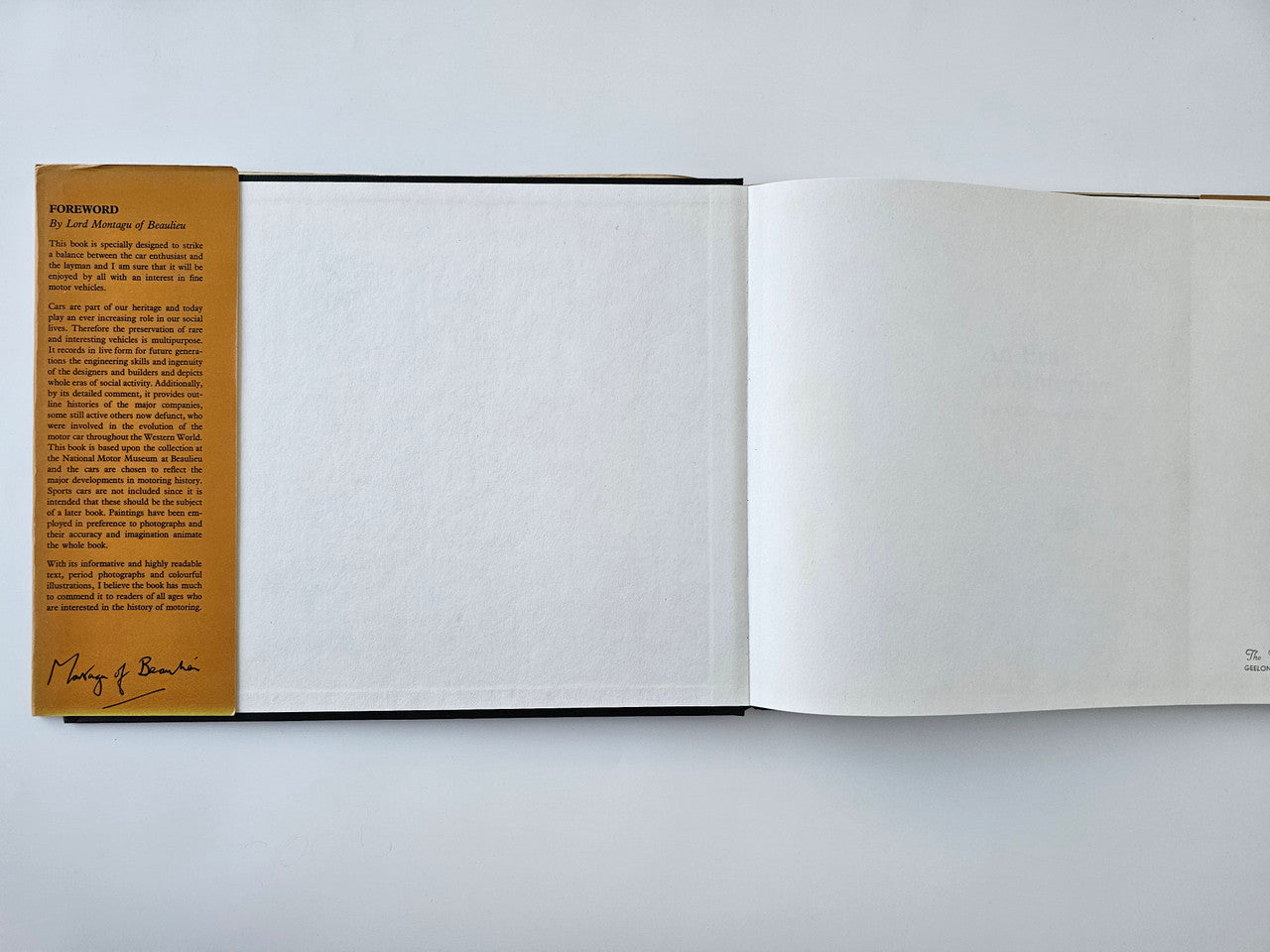 Vintage motoring history book open with empty pages and signed foreword card