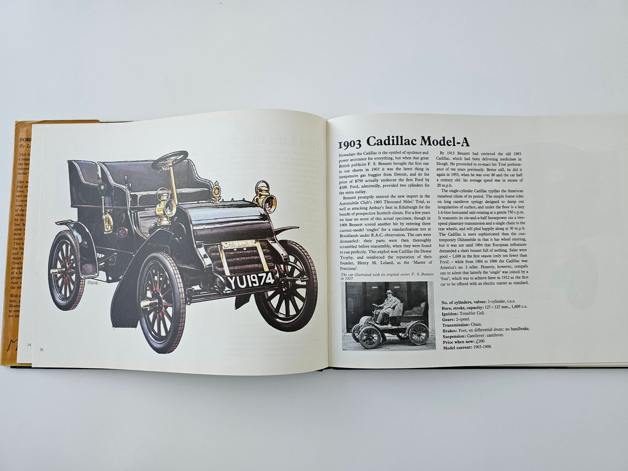 Open vintage automotive history book with 1903 Cadillac Model-A text and car illustration