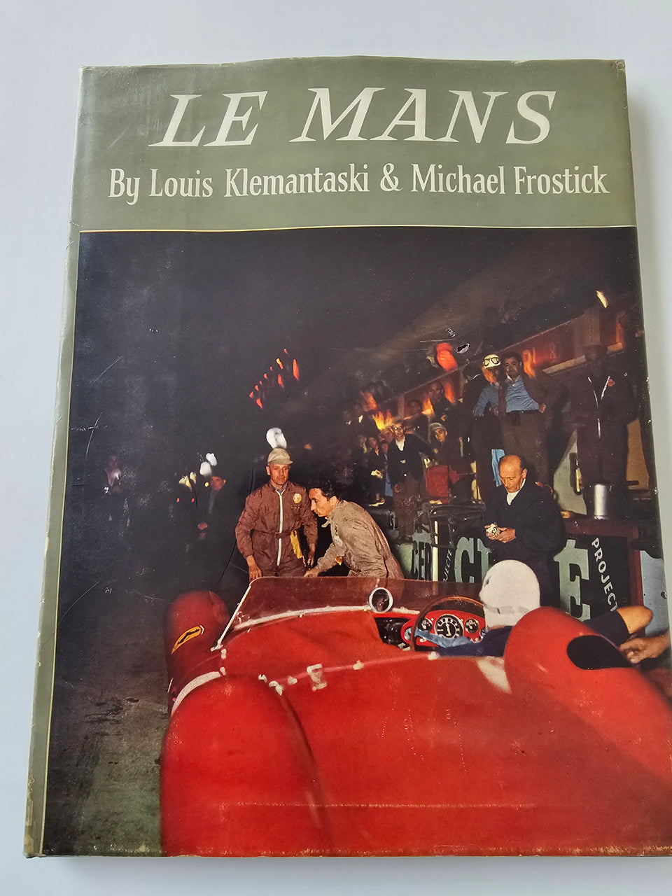 Book cover with “LE MANS” title and red race car against a dark background