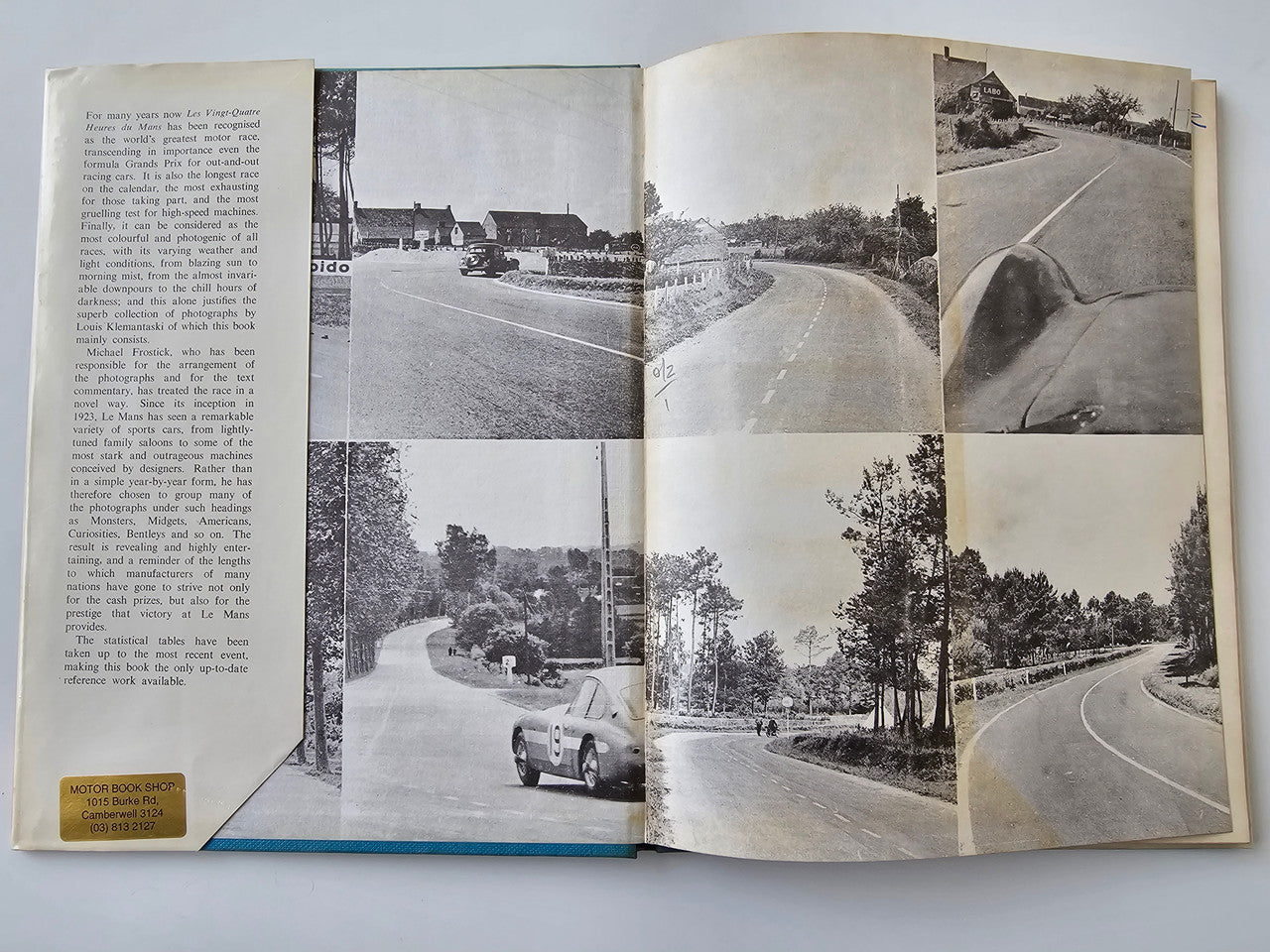Vintage motoring book open to road landscape pages with race car photo panels