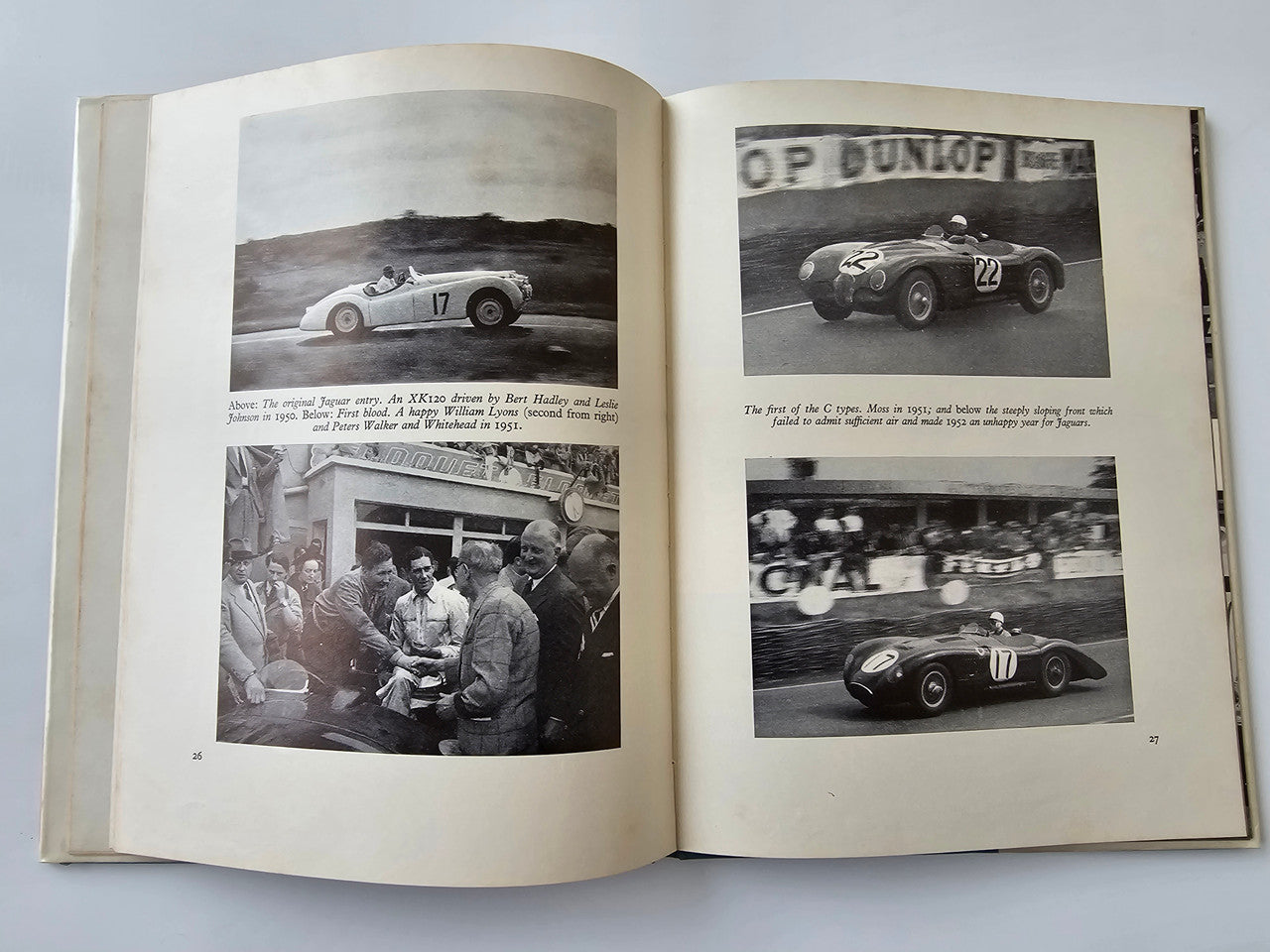 Vintage motoring book open to race car photos and crowd scene photo