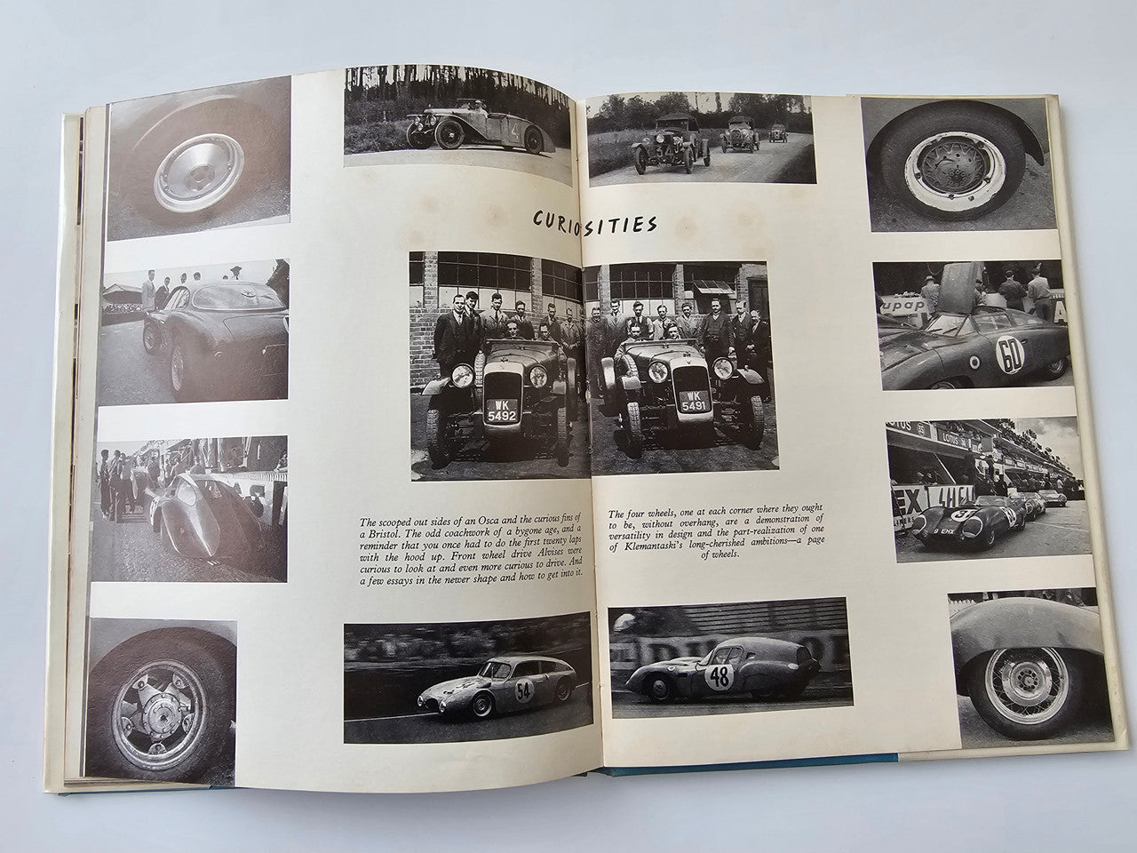 Vintage motoring book open to "CURIOSITIES" page with car detail and group photos
