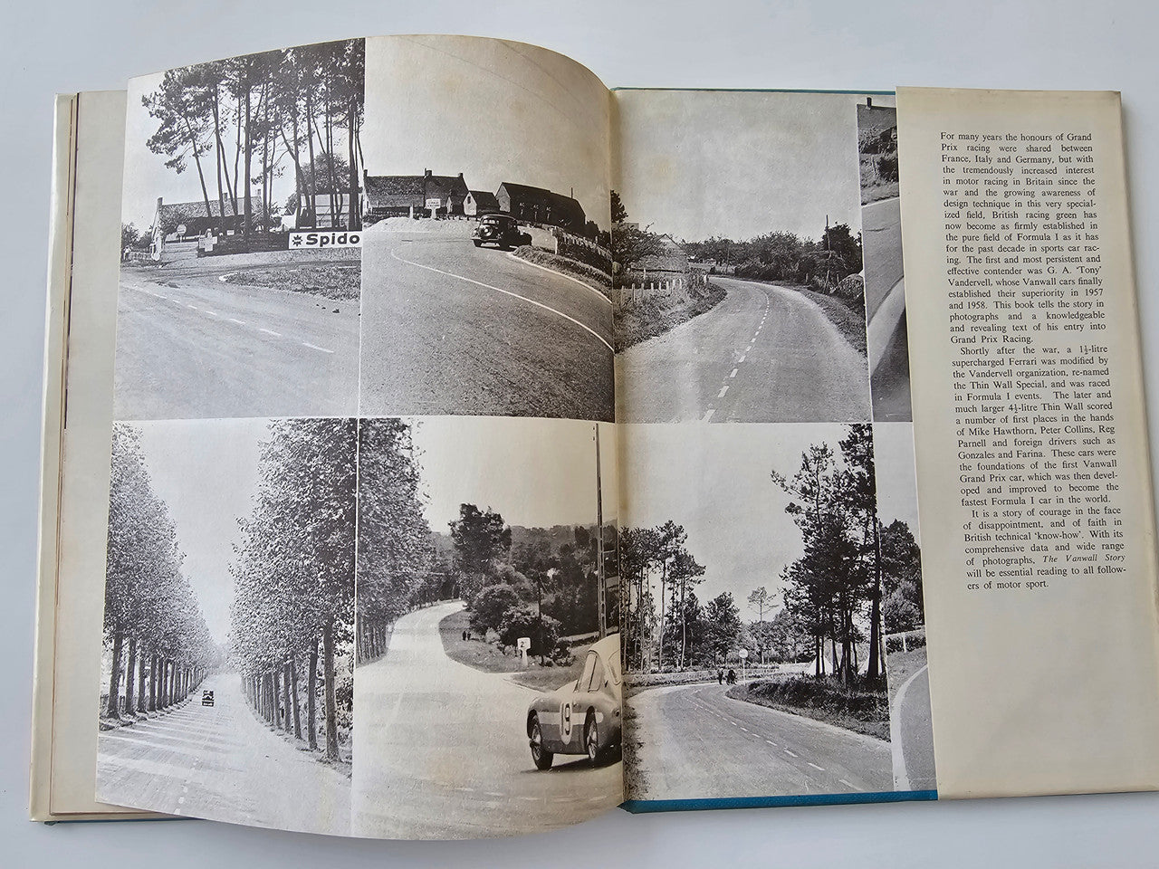 Paperback book open to photo pages with racing track images and printed text