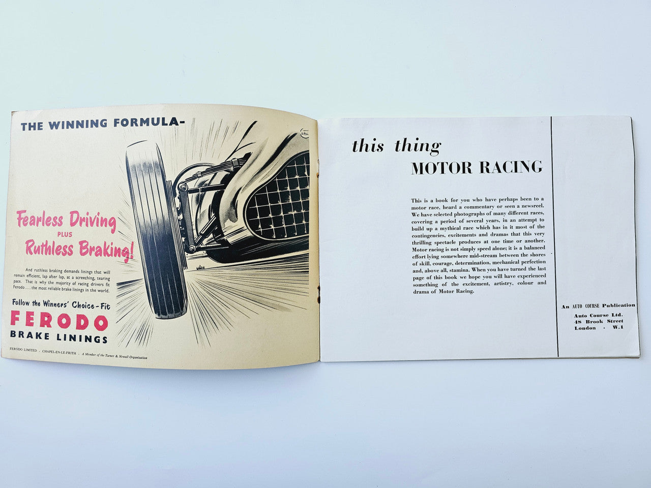 Open motor racing book spread with car photo and columns of printed text on both pages.