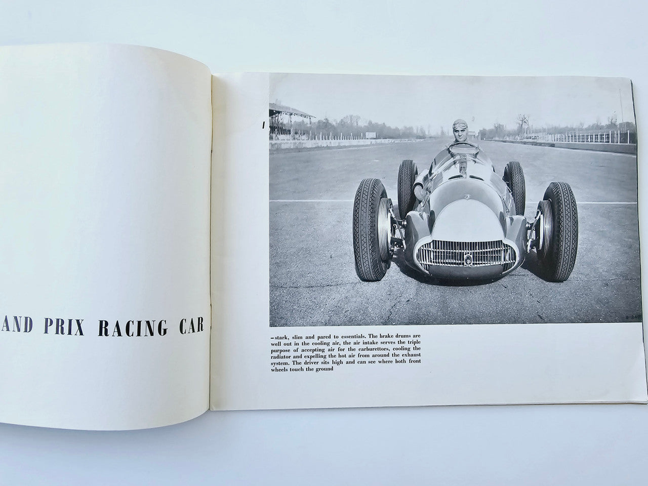 Open book spread with black-and-white front-view racing car photo and paragraph text.