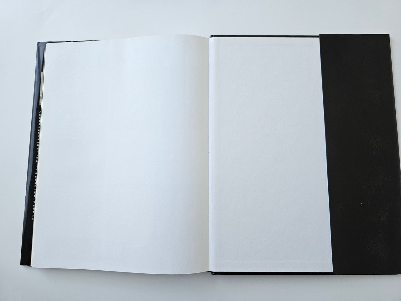 Open guidebook with blank white pages and dark binding