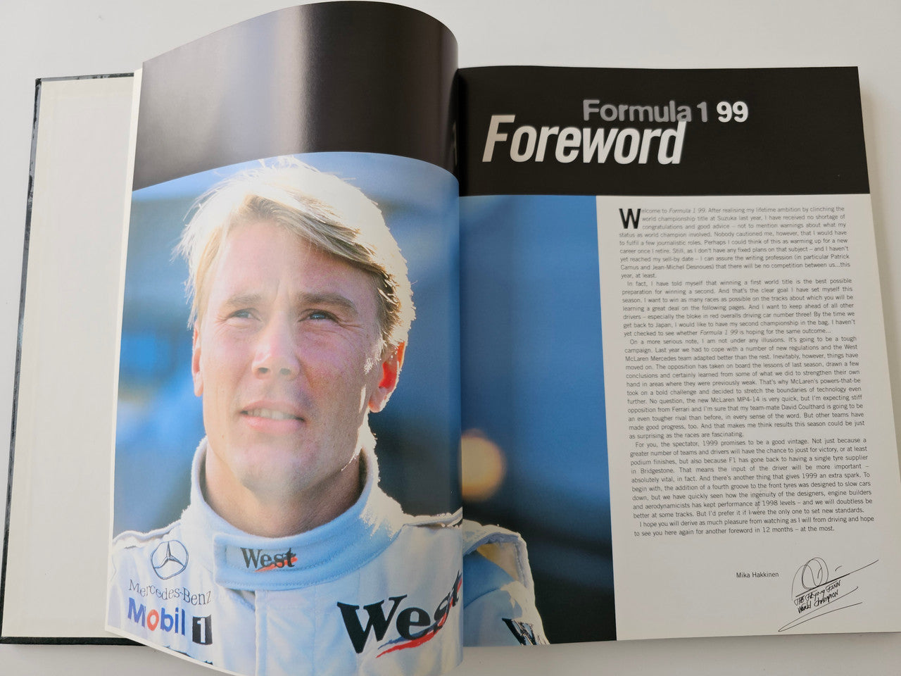 Racing season book opened to foreword page with driver portrait and text