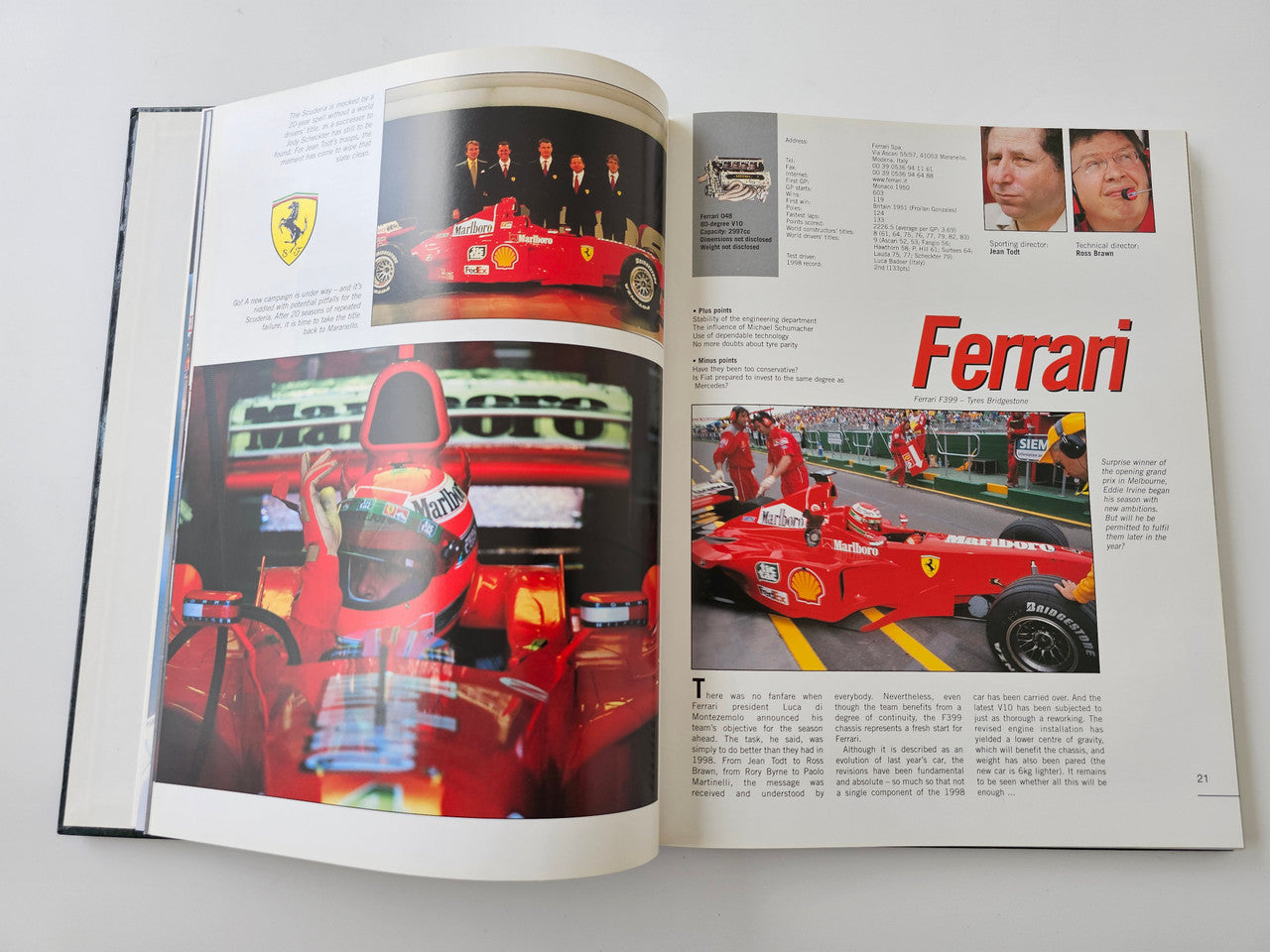 Racing season book opened to team pages with red car photography and text
