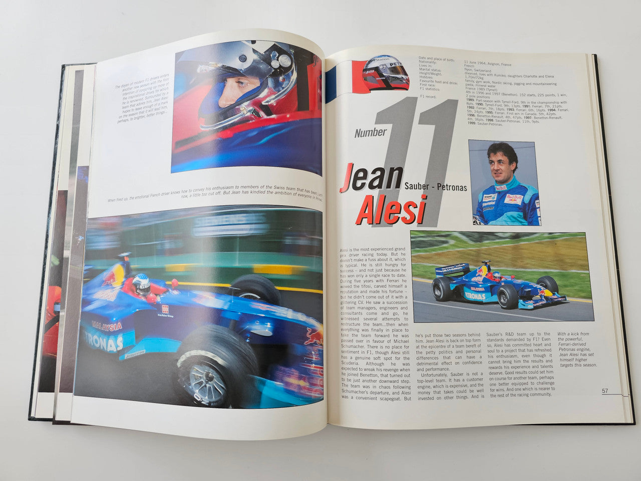 Racing season book opened to driver profile pages with action race car photos