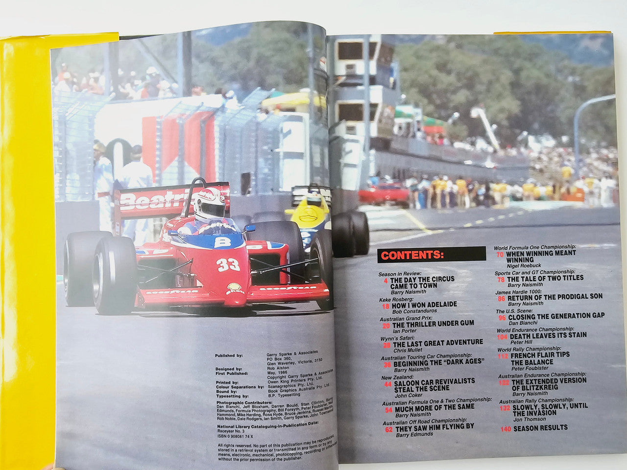 Open motoring magazine spread with red race car photo and Contents list