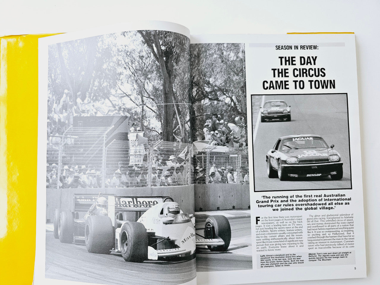 Open motoring magazine spread with black-and-white cars photo and feature headline
