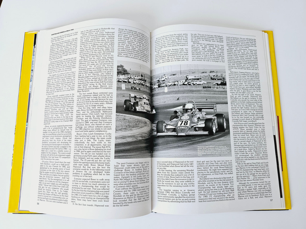 Open motoring magazine spread with black-and-white race car photo centered on page
