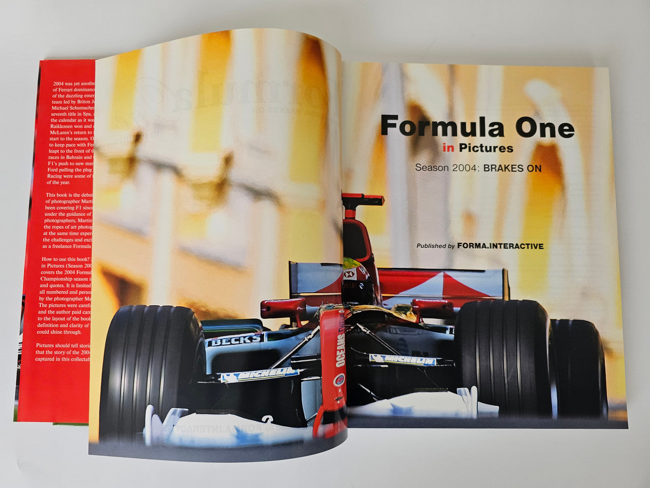 Motorsport photo book open to front car view with 'Formula One' title page text