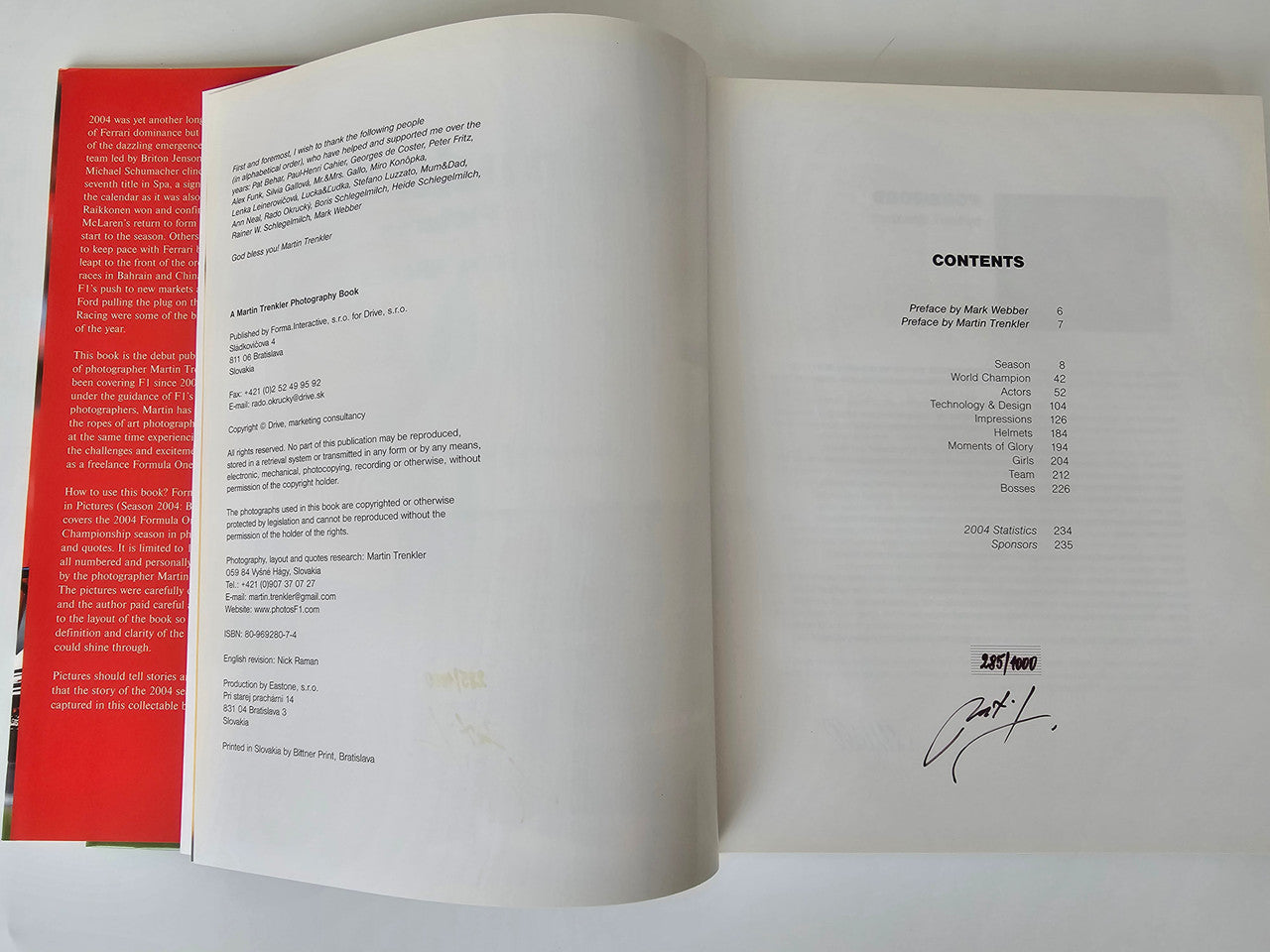 Photo book open spread showing contents list and a handwritten signature