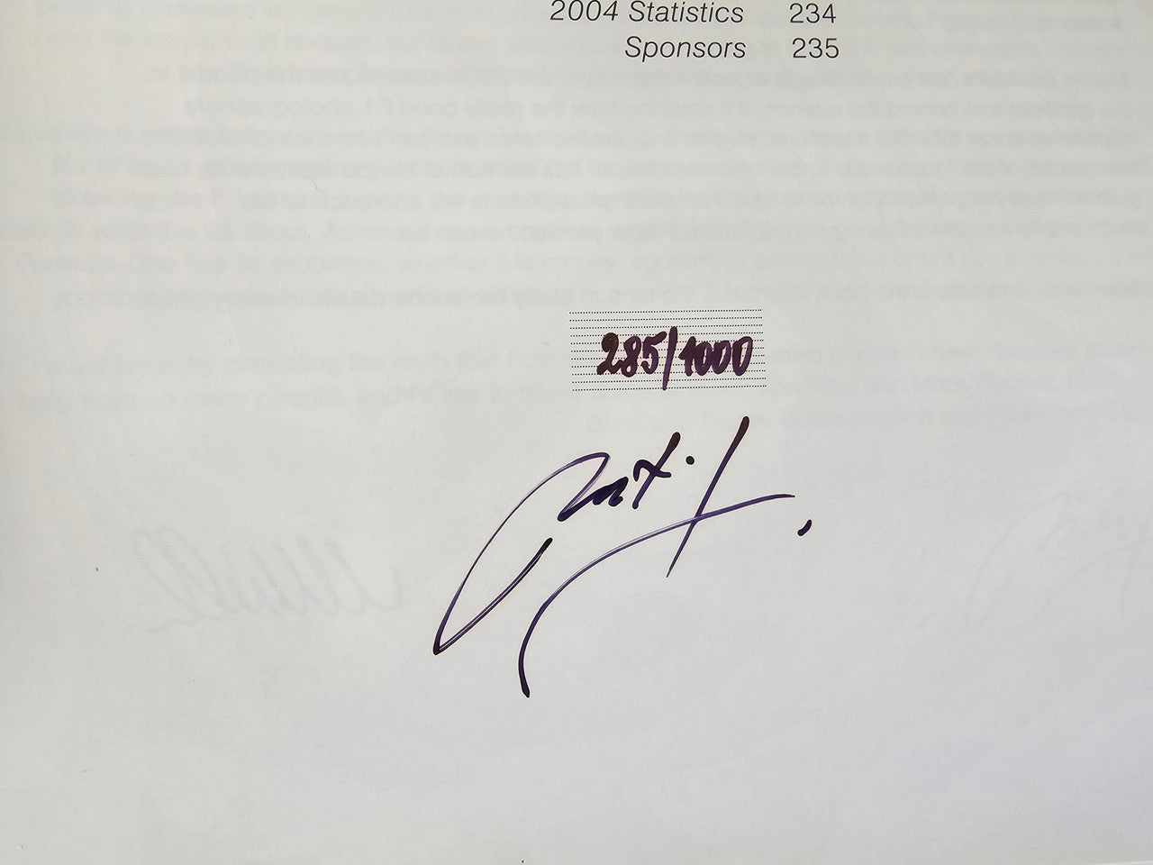 Photo book page close-up with handwritten signature and number markings