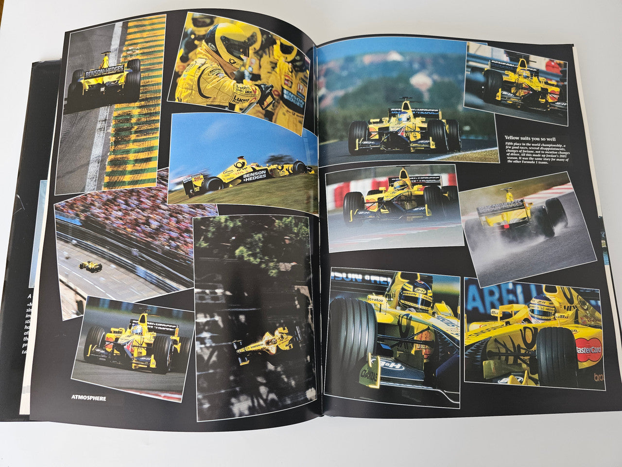 Racing yearbook open photo collage spread with yellow race cars and captions