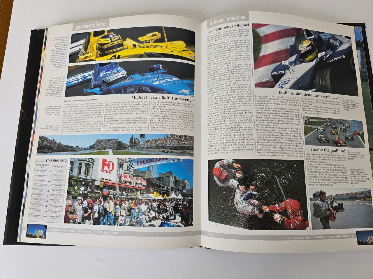 Open motorsport yearbook with race cars, driver portraits, and event photos