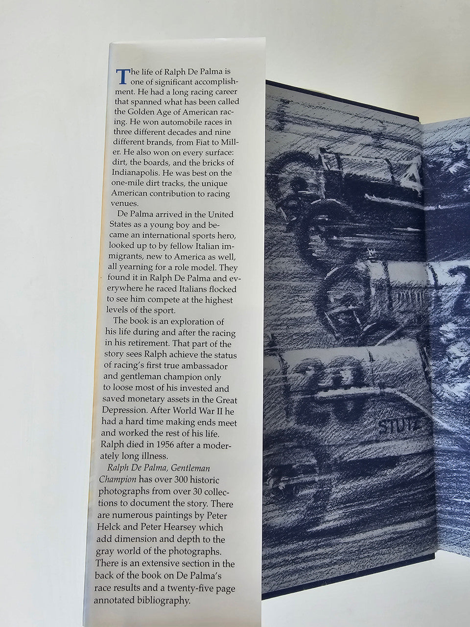 Open book page with dense text and a large grayscale racing car photo