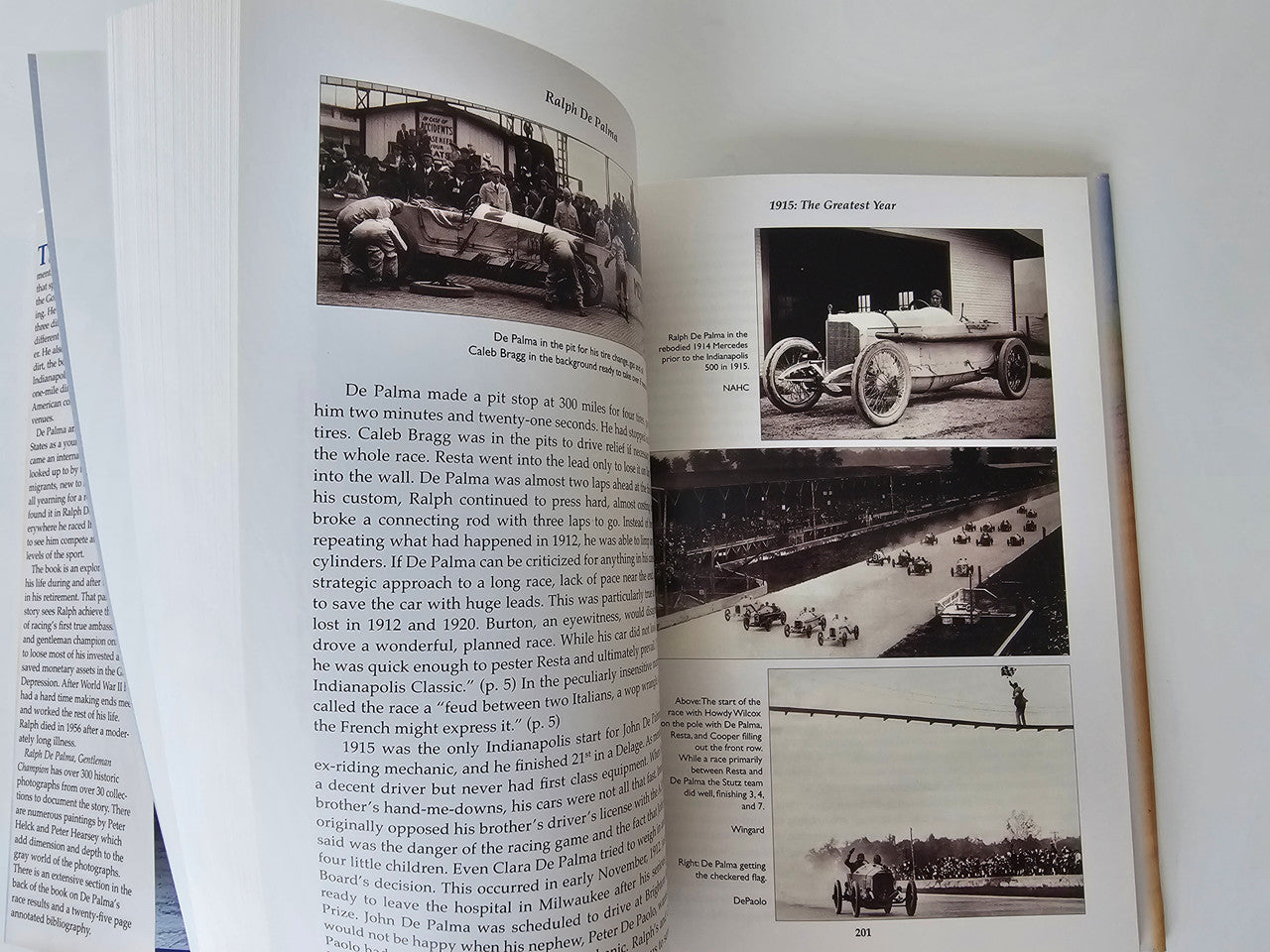 Open book spread with vintage race car photos and columned article text
