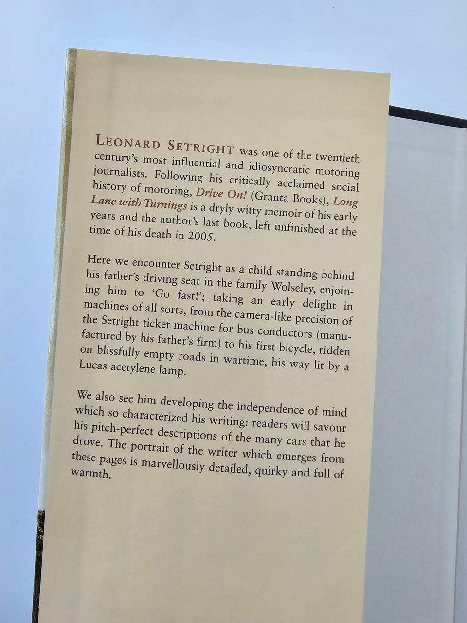 Open book page with dense printed biography text in paragraphs