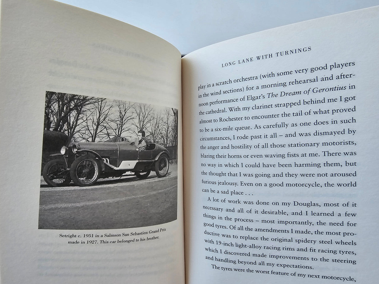 Open book page with black-and-white vintage car photo and printed text