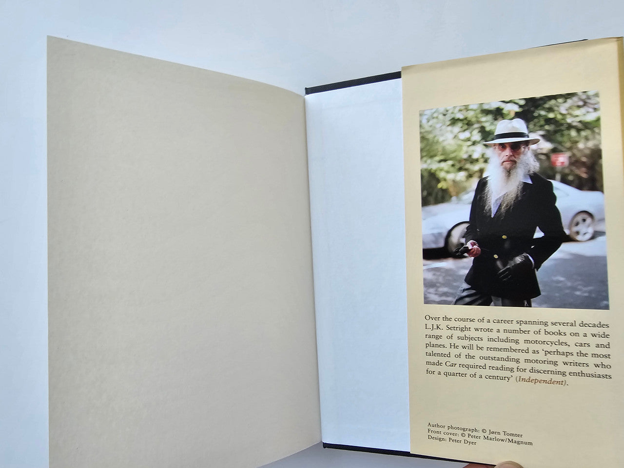 Open book spread with blank page and a printed photo with caption and text