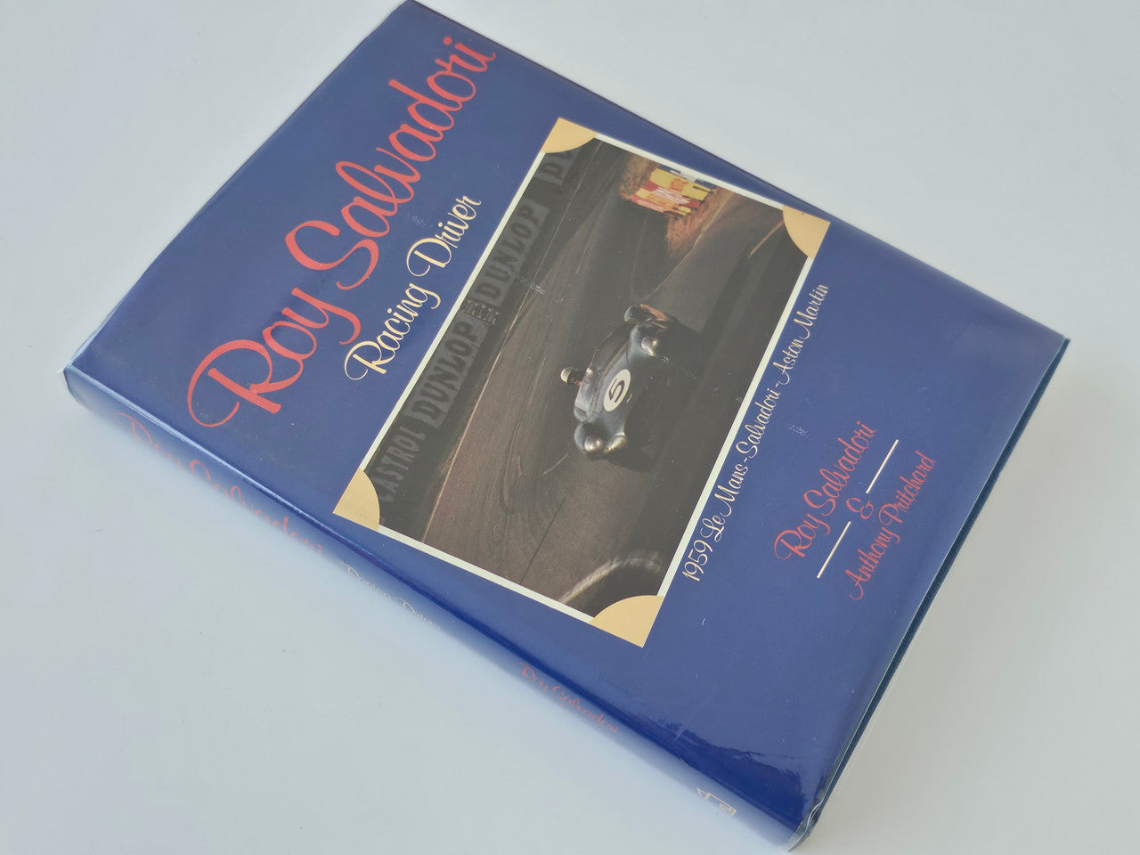 Blue hardback racing driver book with “Roy Salvadori” title and a car photo.