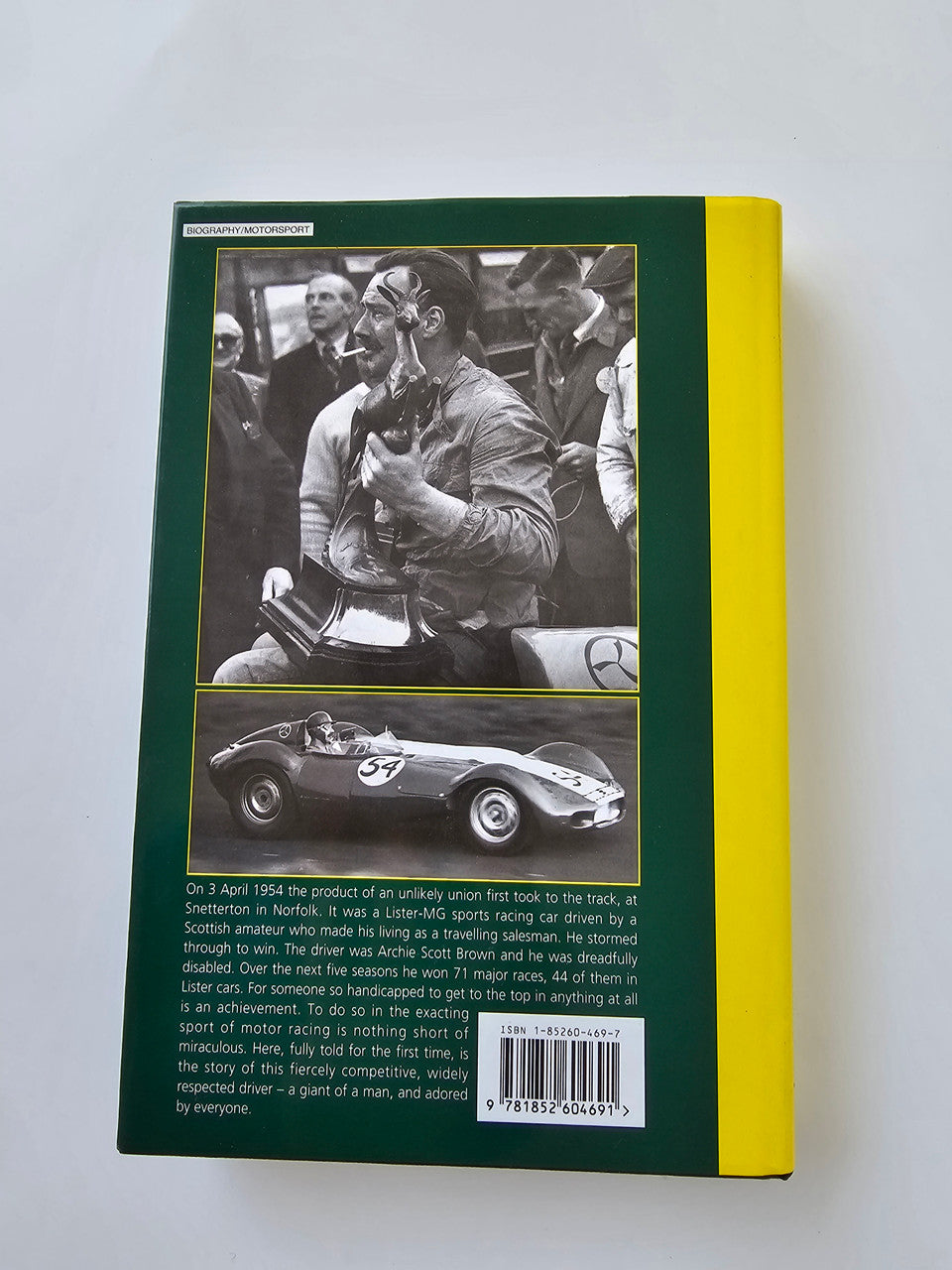 Signed racing biography book back cover with black-and-white driver photo and car