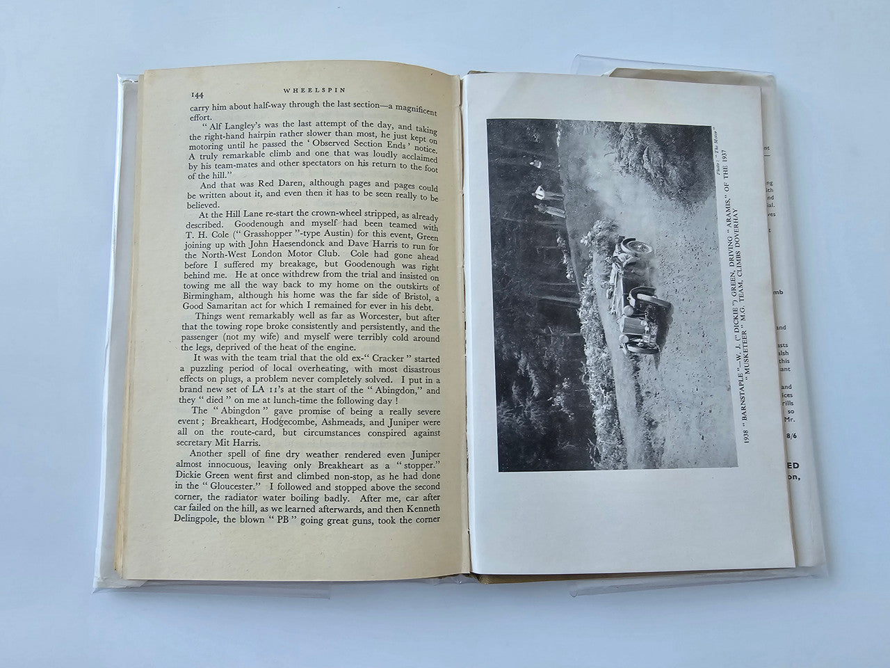 Vintage automotive book open to text page with black-and-white vehicle photograph