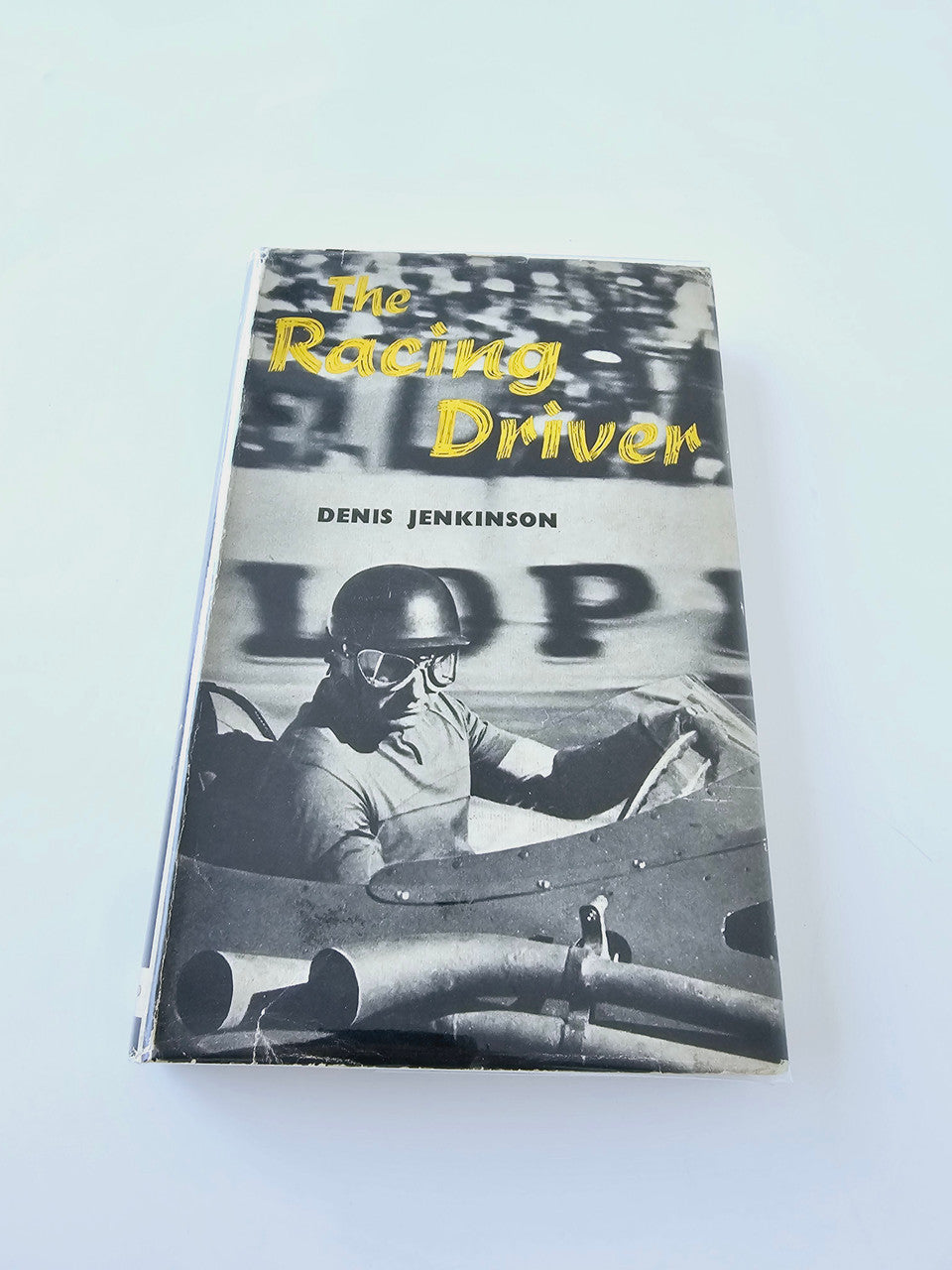 Racing Driver book cover with black-and-white race car photo and yellow title text