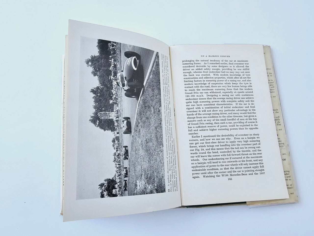 Racing Driver book open to a page with black-and-white road race photo and paragraphs
