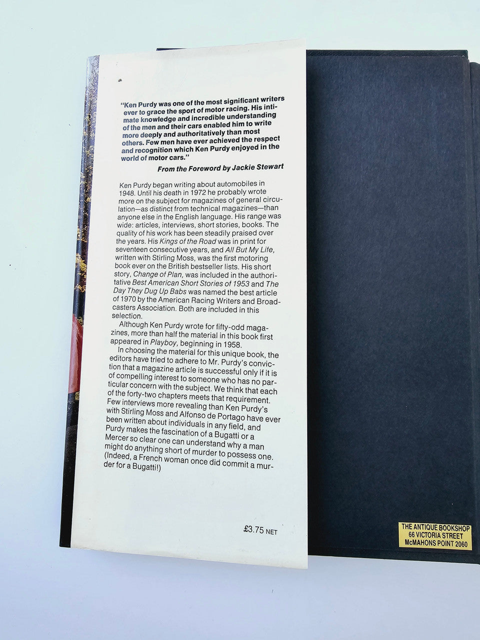 Automobile book open to a black spine side with printed author text page