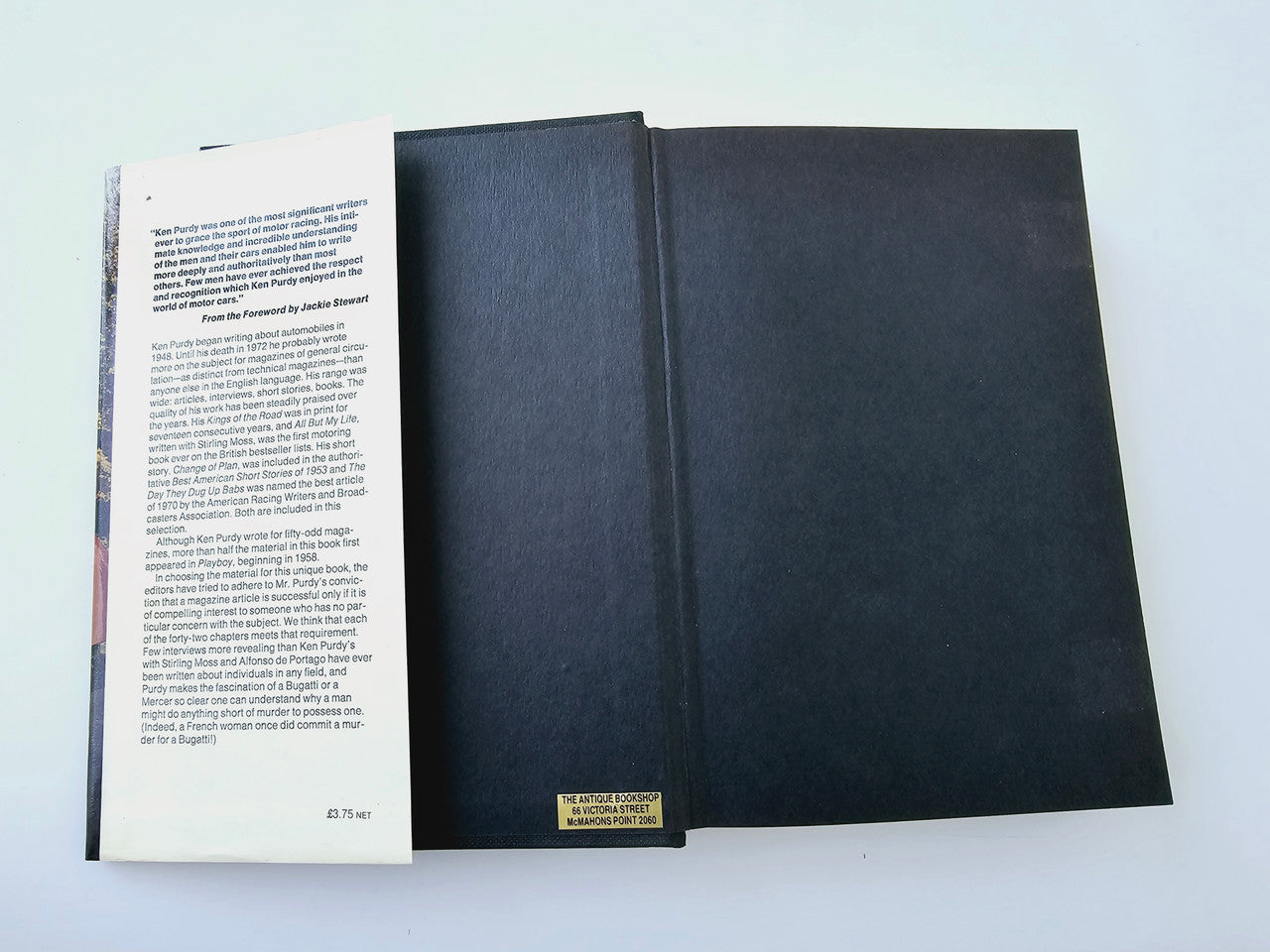 Automobile history book opened, showing left text page and dark blue covers.