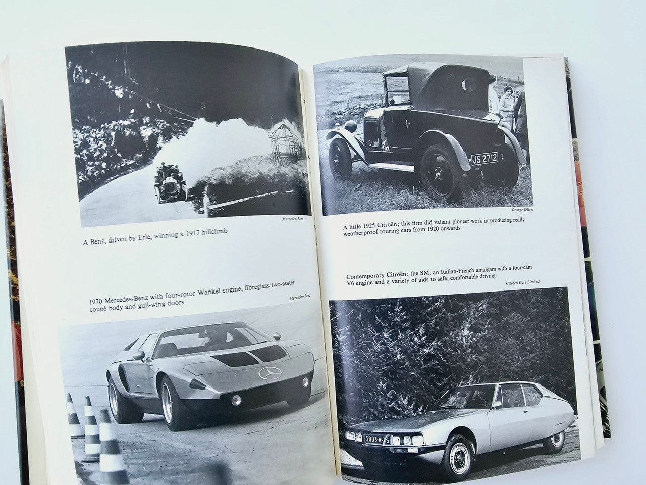 Automobile book spread with black-and-white car photos and captions under images