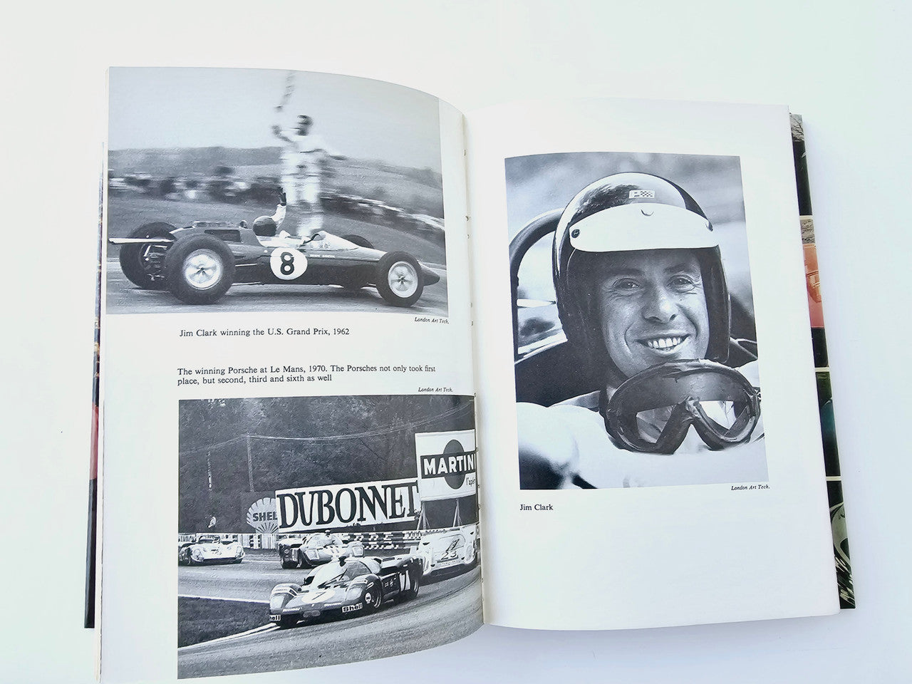 Automobile book open to racing photo pages, including a driver portrait on right