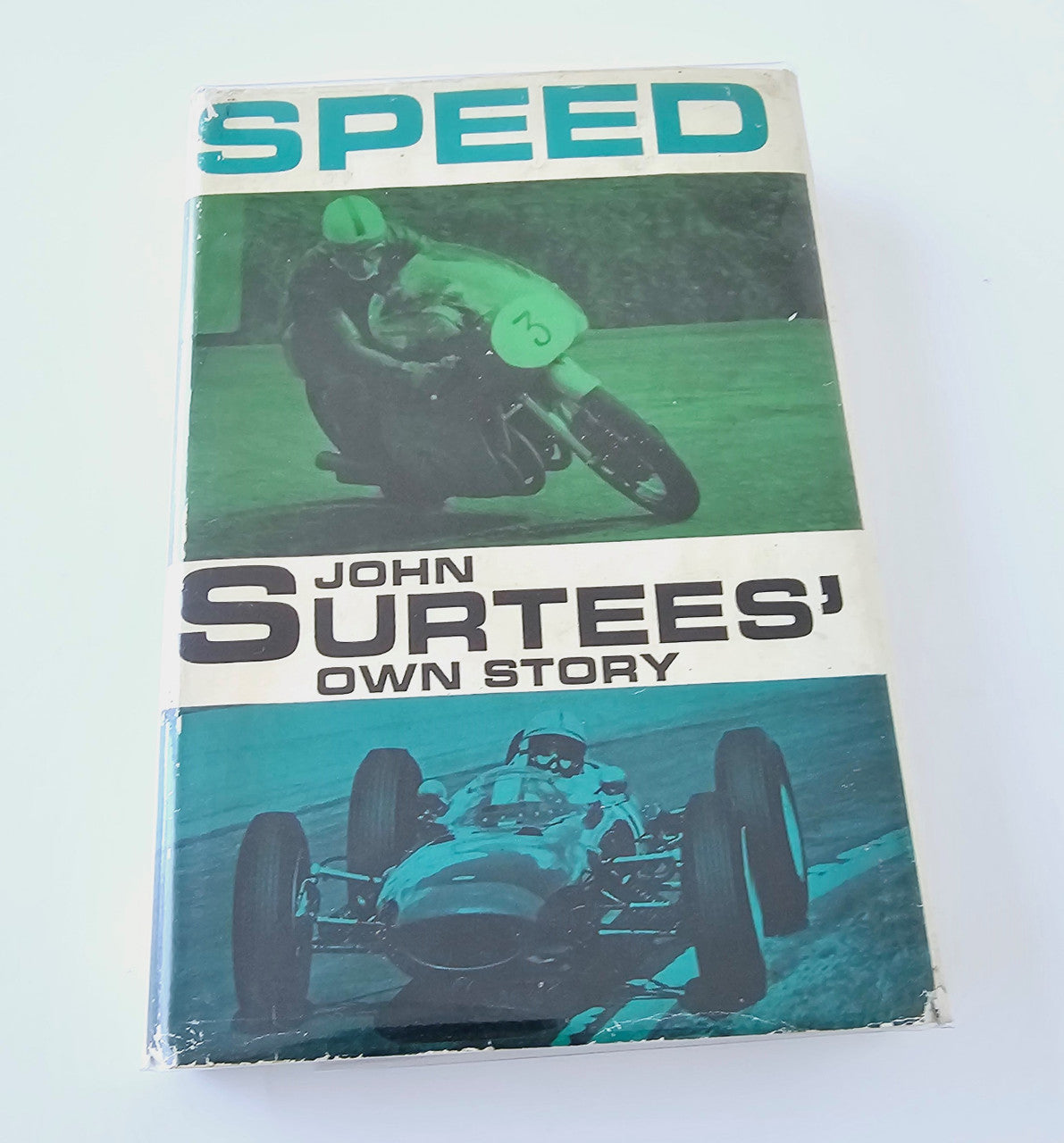 Motorsport book front cover with "SPEED" and John Surtees Own Story title in teal