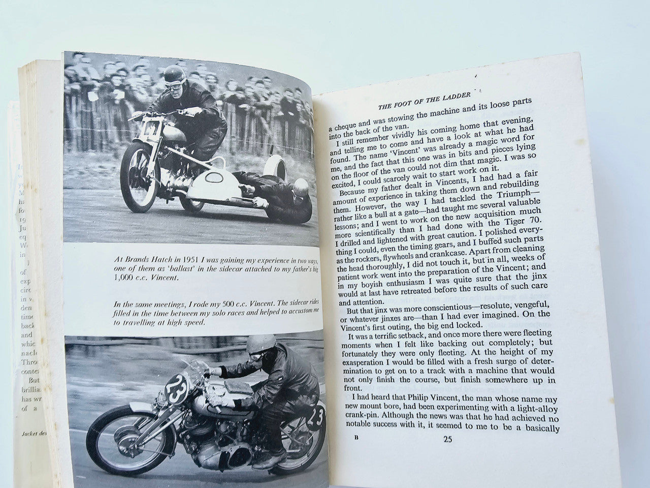 Motorsport memoir book open, black-and-white motorcycle photos with captions and numbered pages