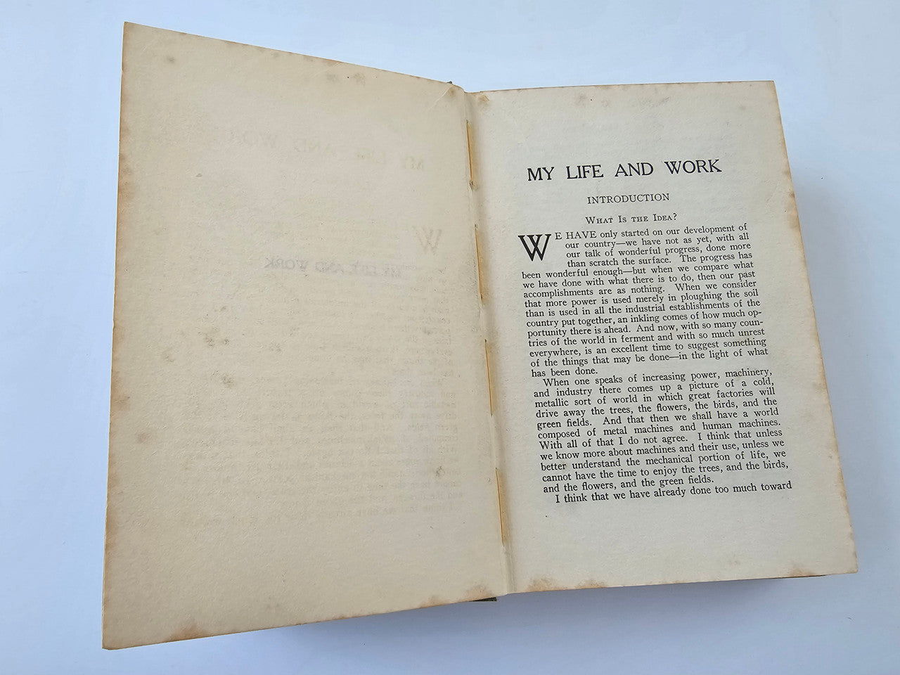 Open book spread with dense printed text and a large drop-cap letter on off-white pages.