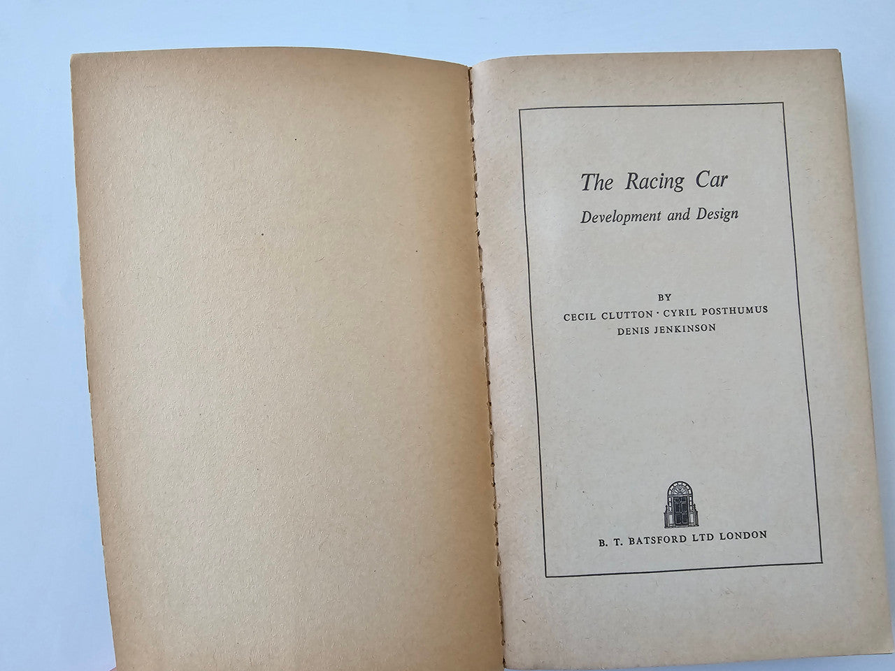 Open book showing beige blank page and printed title page in black