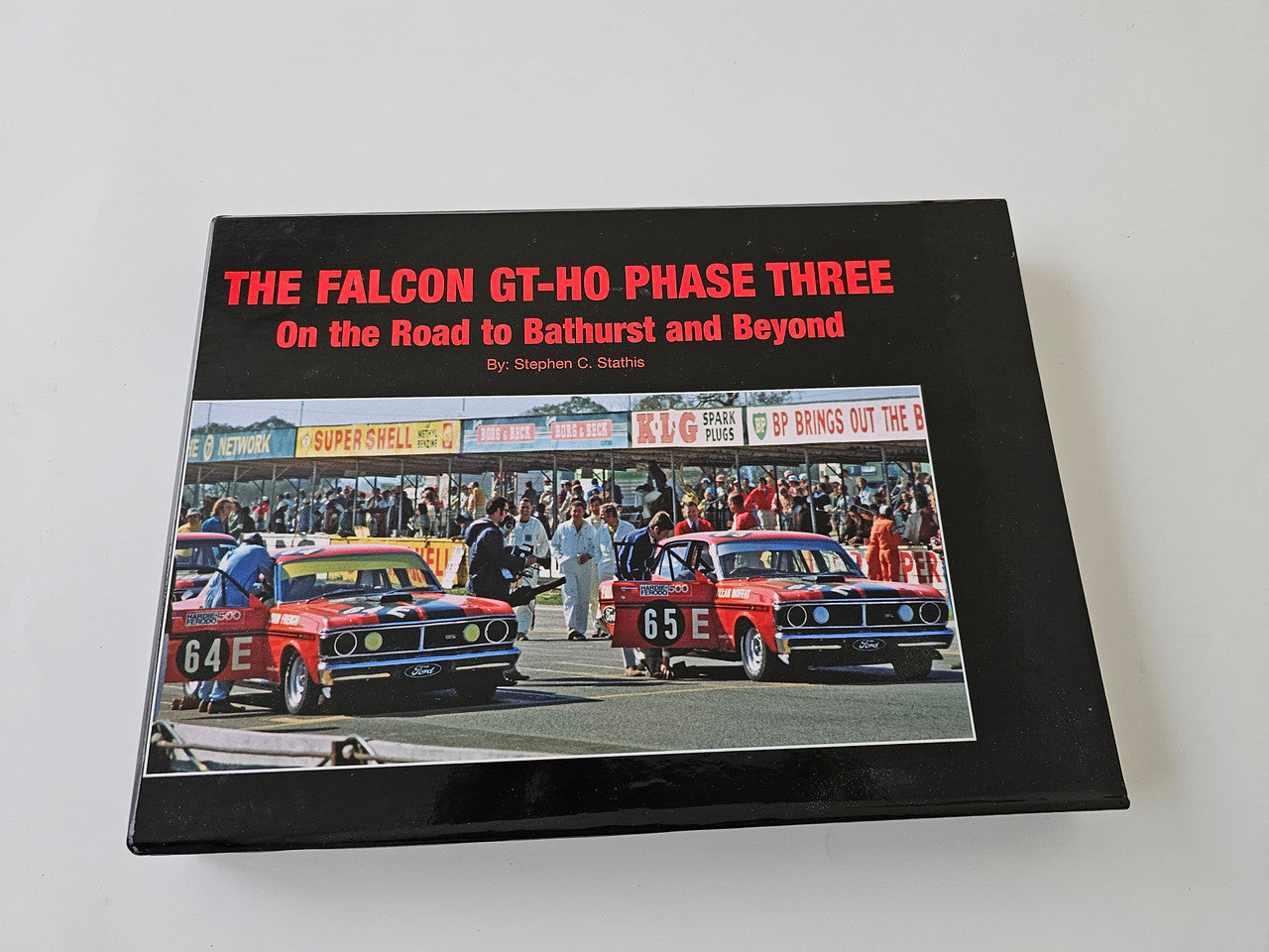 Limited edition automotive book with black cover and photo of two classic race cars