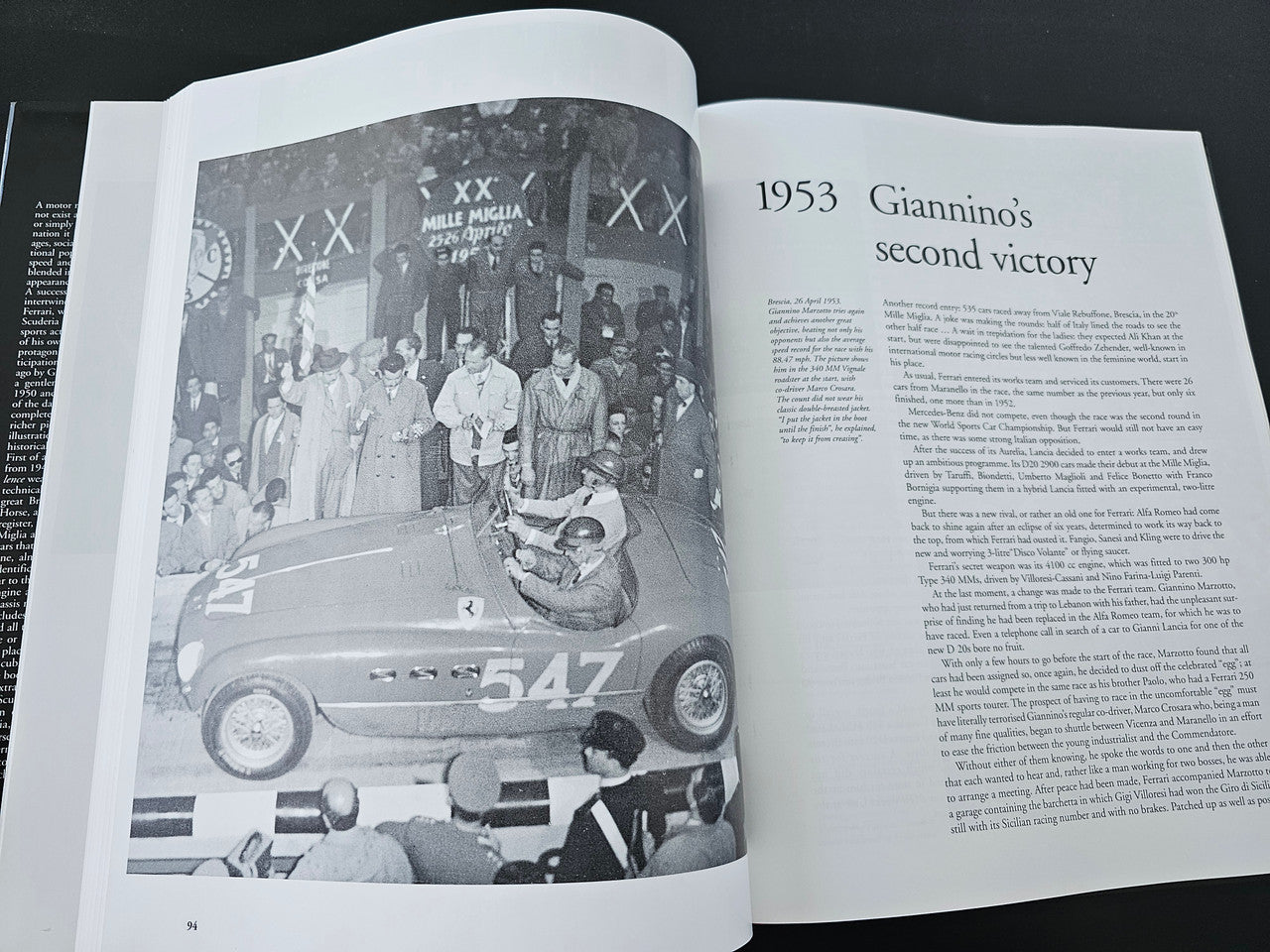 Open book page with a black-and-white vintage race car photo and article text