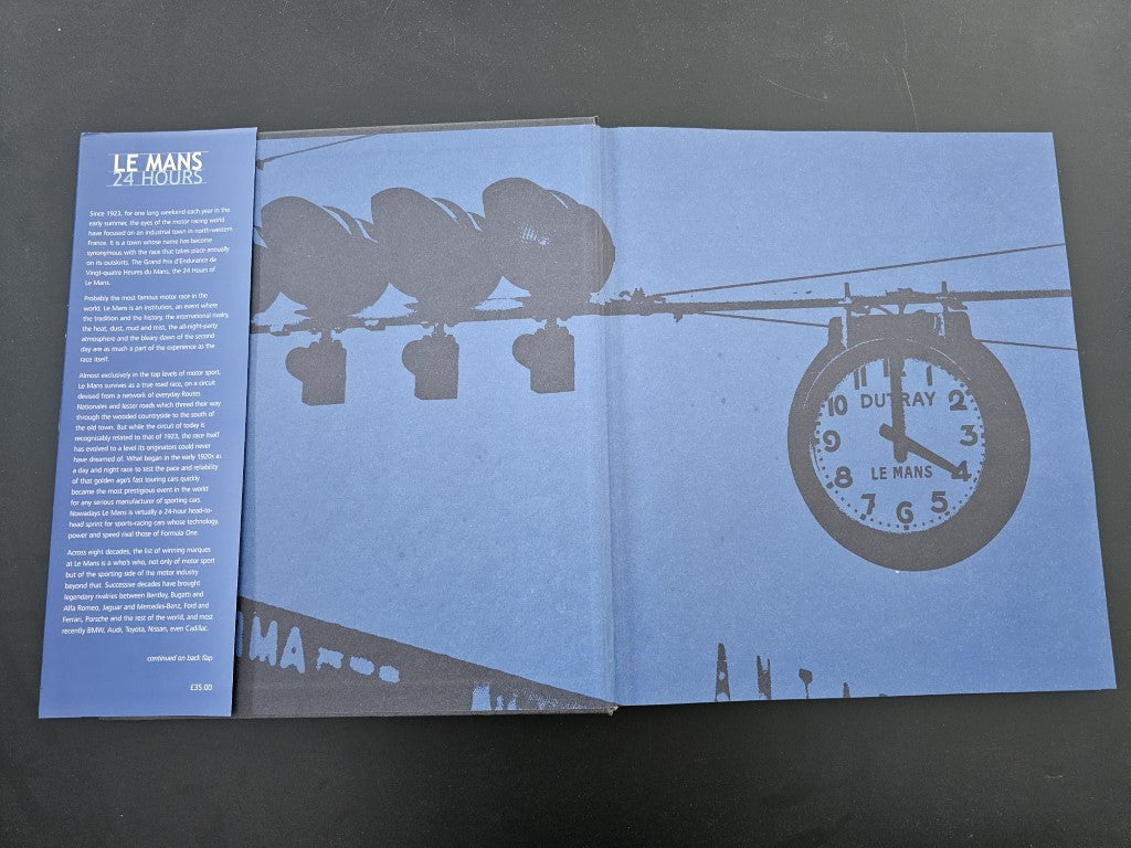 Open race history book with blue cover art and circular emblem on the right page
