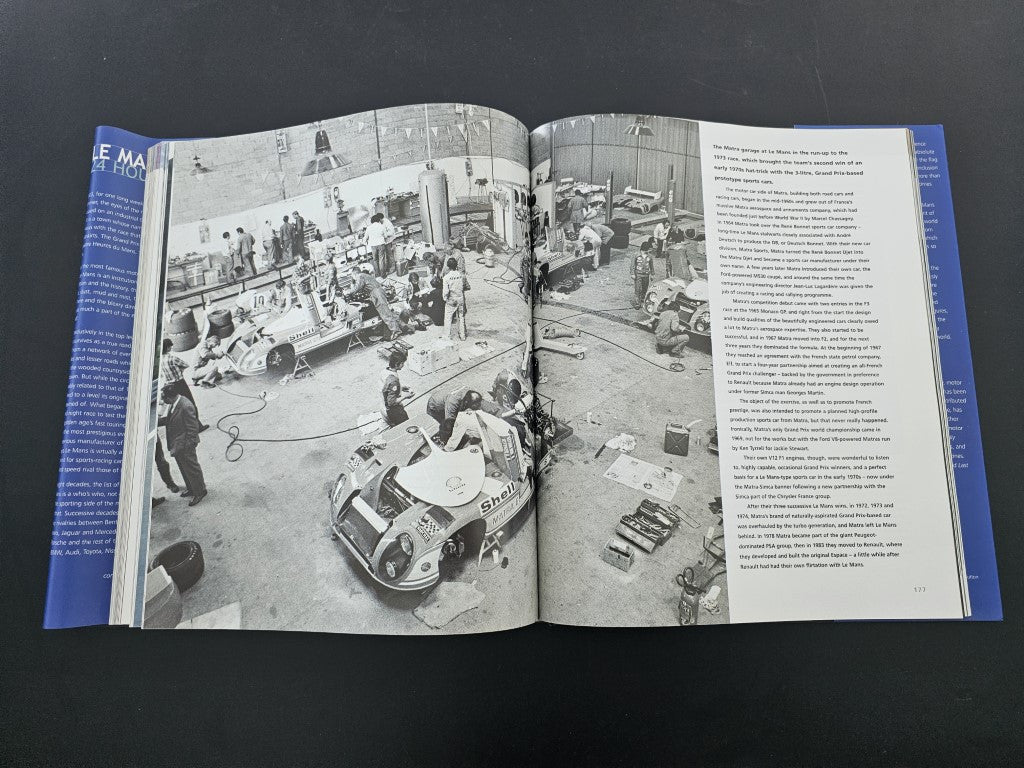 Open book spread with black-and-white factory garage photos and dense text