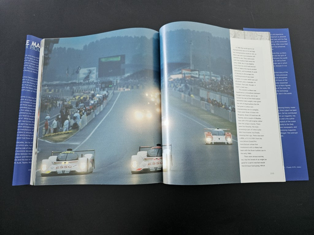 Open book showing race track photo spread with cars on the course