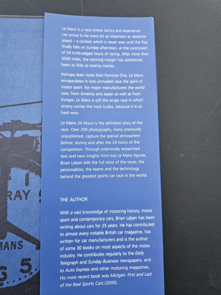 Open book with dense text and a small portrait photo on the left page